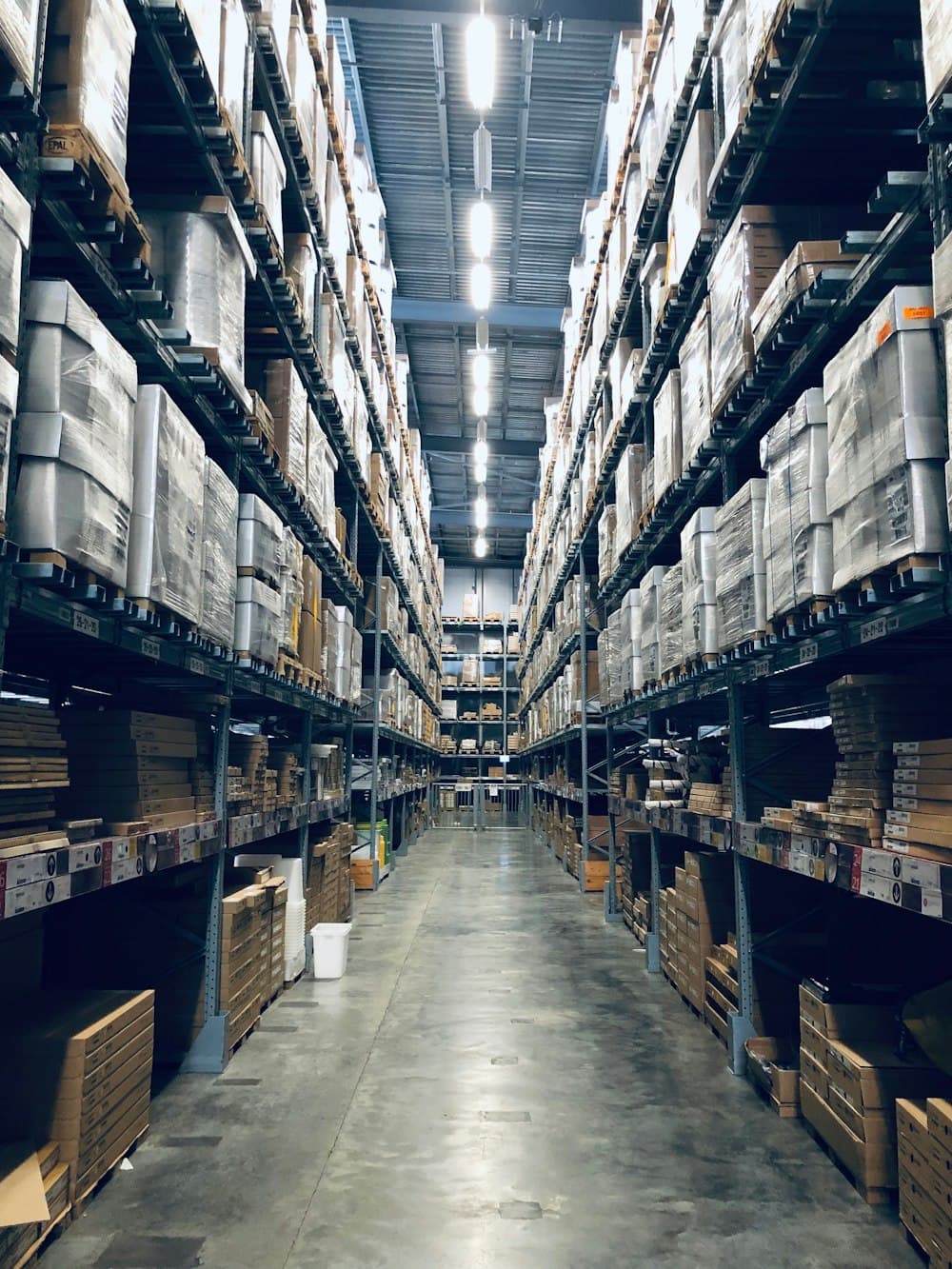 Dark industrial warehouse aisle with tall racking